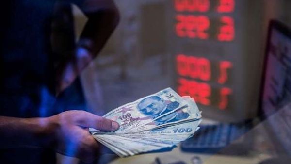 A teller holds Turkish lira banknotes at a currency exchange office in Istanbul. Photograph: Yasin Akgul/AFP/Getty Images