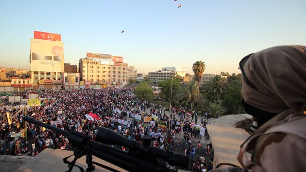 A member of the Iraqi security forces watches over protesters as they demonstrate in support of Prime Minister Haider al-Abadi's reforms. (AFP/Haidar Mohammed Ali)