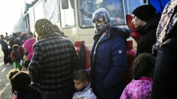 Refugees line up next to a bus in the Idomeni refugee camp. (AFP/File)