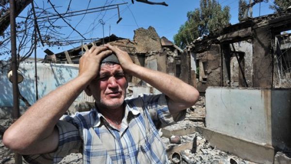 An Ethnik Uzbek holds his head in his hands as he stands beside the wreckage of his burned out home in Osh on June 14, 2010