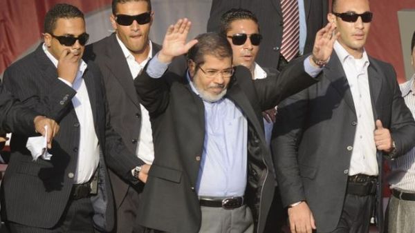 In better times: Flanked by bodyguards, Morsi saluted tens of thousands of Egyptians Tahrir Square on June 29, 2012, when he symbolically swore himself in as the country's first elected civilian president. (AFP PHOTO/MOHAMMED HOSSAM)