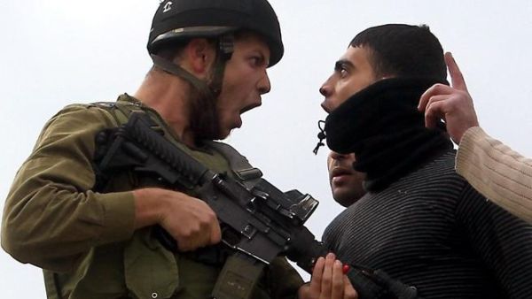 A Palestinian resident of the northern West Bank village of Madama argues with an Israeli soldier after security forces came to intervene in clashes between Palestinian farmers and Israeli settlers from the Yitzhar settlement, on Monday. (AFP PHOTO/JAAFAR ASHTIYEH)