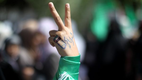 A Palestinian protester whose hand reads in Arabic "Our prisoners are our dignity" makes the victory sign during a demonstration in Gaza City in solidarity with Palestinian prisoners. (AFP PHOTO / MAHMUD HAMS)