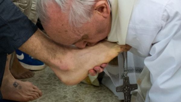 Pope Francis (R) kisses the feet of a young offender after washing them during a mass at the church of the Casal del Marmo youth prison on the outskirts of Rome. (AFP PHOTO / OSSERVATORE ROMANO/HO)