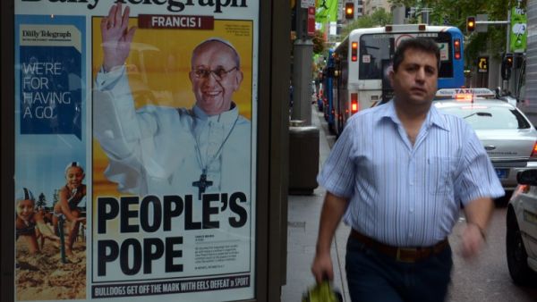 A man walks past an advertising billboard displaying the front page of Sydney's tabloid newspaper the Daily Telegraph with picture of Pope Francis, Argentina's Jorge Mario Bergoglio. (AFP PHOTO/ Saeed KHAN)