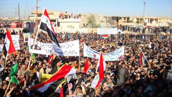 Iraqi protesters hold banners during a demonstration demanding the ousting of Prime Minister Nouri al-Maliki on Friday. (AFP)