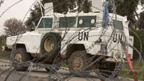 A UN vehicle is seen driving behind barbwire as UN peacekeepers leave a post, in the demilitarised United Nations Disengagement Observer Force (UNDOF) zone, in the Golan Heights. (AFP PHOTO/JACK GUEZ)