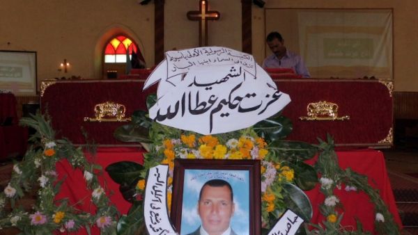 The coffin of Ezzat Hakim Attallah (portrait), who died in the eastern Libyan city of Benghazi, days after being arrested on charge for allegedly seeking to convert Muslims in Libya, is seen during his funeral service at a church in Assiut city, 386 kilometers south of Cairo, on March 13, 2013. (AFP PHOTO / STR)
