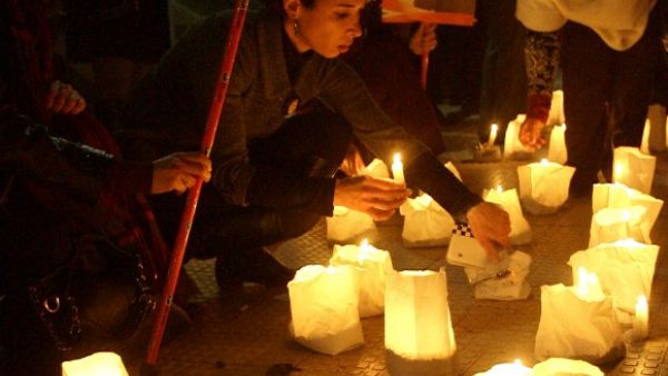 Lebanese supporters of the Mostaqbal Movement bloc light candles during a vigil as others holds pictures of former Lebanese premier Rafiq Harir and his son former prime minister Saad Hariri in the southern Lebanese city of Sidon. [AFP]