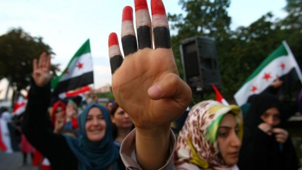 A woman raises her hand painted with the colors of the Egyptian flag among other protesters staging a demonstration in the Turkish capital in Ankara on August 19, 2013. (AFP)