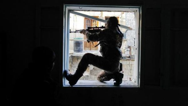 A member of Liwa (Brigade) Salahadin, a Kurdish military unit fighting along side rebel fighters, aims at a regime fighter in the besieged district of Karmel al-Jabl in eastern Aleppo. (TOPSHOTS/AFP PHOTO/JAVIER MANZANO)