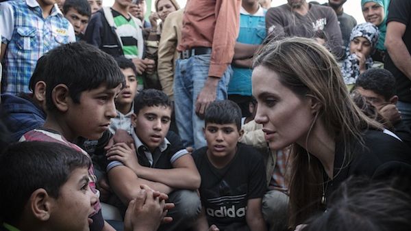 US actress Angelina Jolie speaks with Syrian refugees in a Jordanian military camp based the the Jordan-Syria border on Tuesday. (AFP)