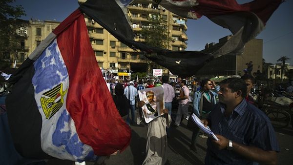 An Egyptian protester carries a picture of late president Anwar al-Sadat during a demonstration against President Mohammed Morsi on Friday in Tahrir Square, Cairo. AFP photo
