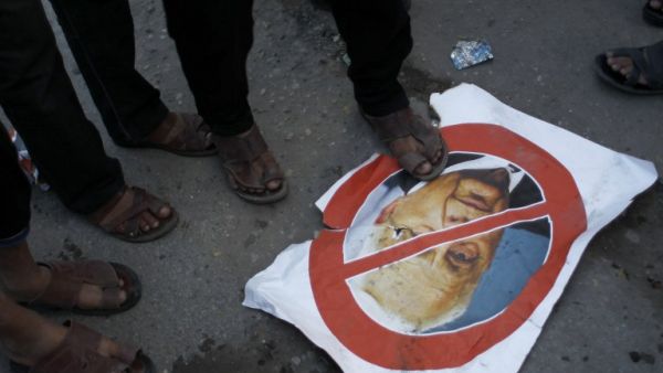 Palestinian supporters of the Islamic Jihad step on a poster bearing a portrait of former Israeli premier Ariel Sharon who died after being in a coma for eight years, aged 85. (AFP)