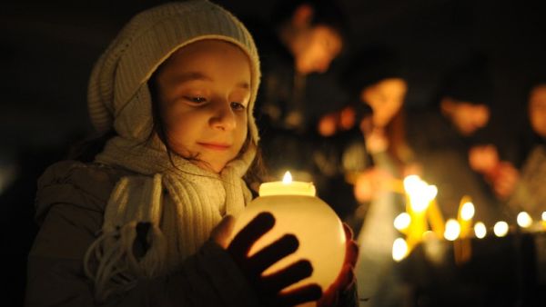 A young girl holds a candle outside Saint Gregory the Illuminator church in the Armenian capital of Yerevan during an Armenian Orthodox Christmas Eve church service on January 5, 2014. (AFP)