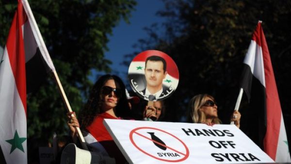  Protesters hold pictures of Syrian President Bashar al-Assad and banners against a potential air strike against Syria in front of the US Embassy in Sofia on September 4, 2013. (AFP)