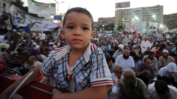  An Egyptian boy poses for the camera as supporters of the deposed president Mohamed Morsi attend the sit-in at Rabaa al-Adawiya square in Cairo (AFP/FAYEZ NURELDINE)