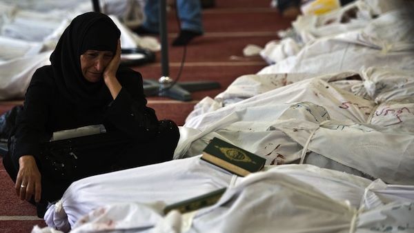 An Egyptian woman mourns over the body of her daughter wrapped in shrouds at a mosque in Cairo on August 15, 2013, following a crackdown on the protest camps of supporters of ousted Islamist president Mohamed Morsi the previous day. (AFP)
