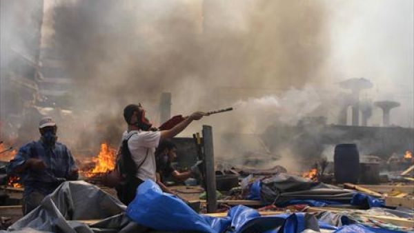 A supporter of the Muslim Brotherhood and Egypt's ousted president Mohamed Morsi fires fireworks towards police during clashes in Cairo on Wednesday. (AFP)
