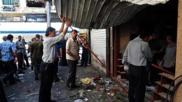 Syrians inspecting the damage in central Damascus following two explosions on Tuesday. AFP photo