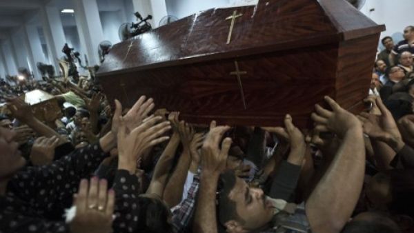 Egyptian Copts carry coffins down the aisle of the Virgin Mary Coptic Christian church in Cairo's working class neighbourhood of Al Warrak, on October 21, 2013. (AFP)

