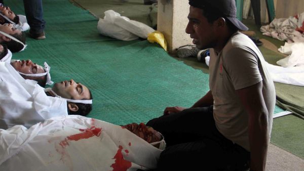 An Egyptian youth mourns over bodies laid out in Tawhid Mosque, close to Ramses Square, in Cairo (AFP/KHALED KAMEL)