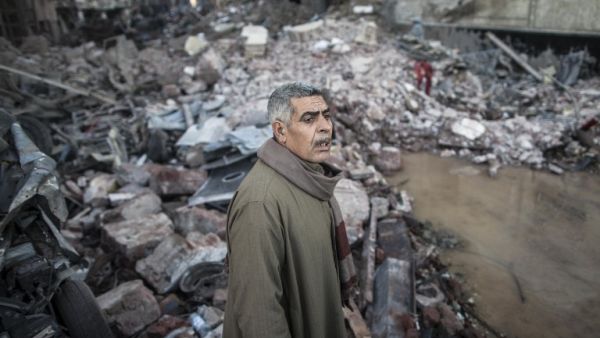 An Egyptian man stands amidst debris car at the site of a powerful car bomb explosion in the Egyptian city of Mansoura, North of Cairo, on December 24, 2013.  (AFP)