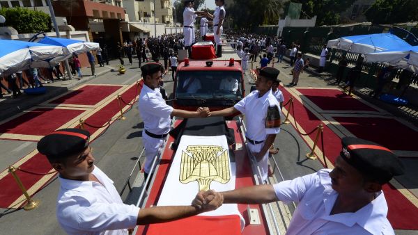 Egyptian policemen stand on vehicles carrying the coffins of their comrades during their funeral in Cairo (AFP/KHALED DESOUKI)
