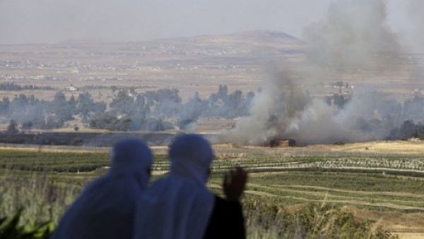 Two Israeli druze women sit looking over the clashes between Syrian forces in the Golan Heights on Thursday. AFP Photo