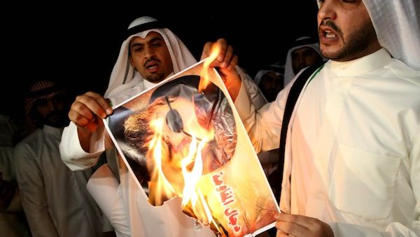 Anti-Hezbollah protesters burn an image of Hezbollah's leader, Sayyed Hasan Nasrallah. (Al Bawaba/AFP file photo)