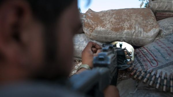  A Syrian rebel fighter points his rifle through a hole in sandbags as he holds a position in a trench, 100m away from the regime-controlled military base of Wadi Deif in Idlib province. AFP photo