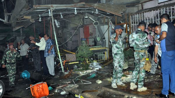 Iraqis and policemen gather at the scene of an explosion in Nasiriyah, south of the Iraqi capital Baghdad. (AFP/STR)