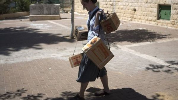 An Israeli woman carries gas masks as she leaves the distribution centre in Jerusalem on August 26, 2013 (AFP)

