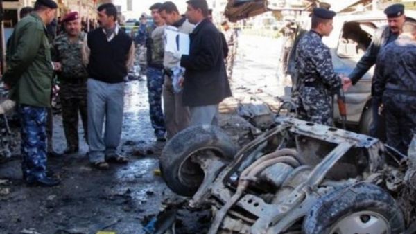 Police inspect the aftermath of a car bomb in Kirkuk