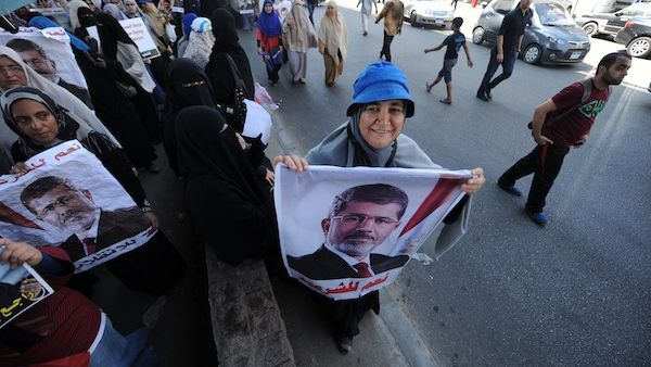 An Egyptian supporter of deposed president Mohamed Morsi holds a portrait of him during a demonstration against the government in al-Nasr street in Cairo on July 30, 2013. (AFP)