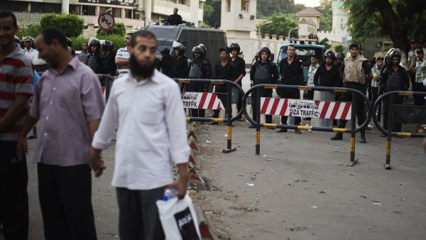Egyptian riot policemen stand by the Giza central Police station as members of the Muslim Brotherhood and supporters of ousted president Mohammed Morsi march in his support. (AFP/GIANLUIGI GUERCIA)