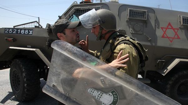 An Israeli soldier wags his finger at a Palestinian protester is seized by an during the evacuation of Palestinian protesters as they were trying to close the main road leading to the Israeli settlment of Efrata in the West bank town of Bethlehem on August 16, 2013 (AFP)