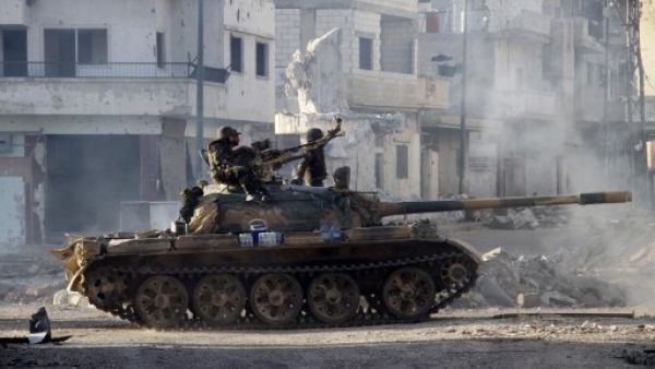 Syrian army troops drive through the ravaged streets of Qusayr in the central Homs province on Wednesday. AFP Photo