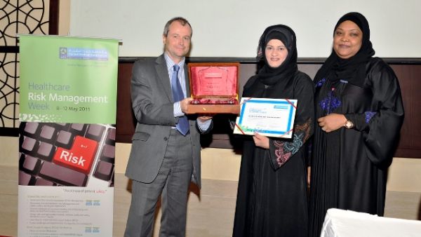 Dr. Moza Alishaq hands over a memento of appreciation to Gary Needle in the presence of Dr. Badriya Al Ali