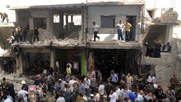 A handout picture released by the Syrian Arab News Agency (SANA) on June 23, 2013, shows civilians and security at the scene of a bombing in the Mazzeh 86 area of the Syrian capital Damascus. (Source: AFP/SANA)