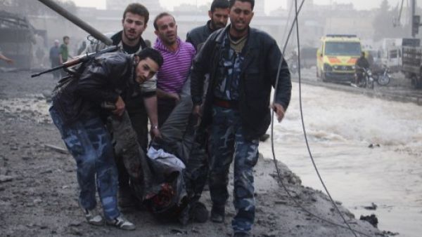 Rebels and civilians carry the body of a man killed after an air strike by pro-government forces on the Syrian city of Aleppo on November 28, 2013. (AFP)
