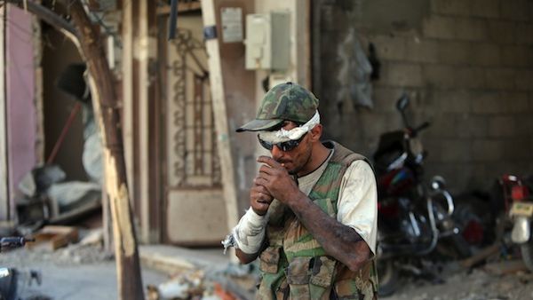 A Syrian government forces soldier lights a cigarette on July 31, 2013 in the al-Khalidiyah district of Syria's central city of Homs (AFP)