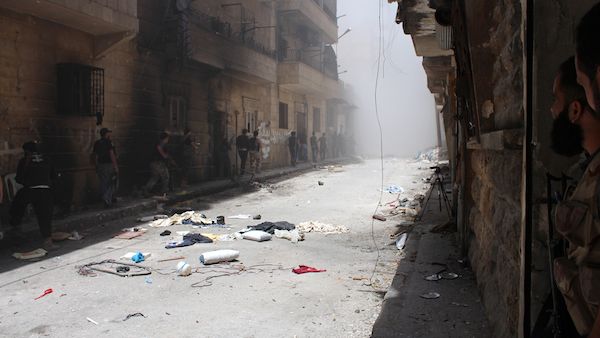 Syrian rebels gather outside a building which they blew up to target a regime sniper (Source: AFP/SALAH AL-ASHKAR)
