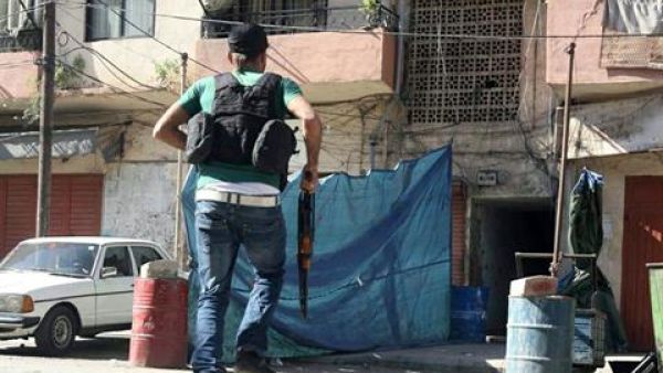 A gunman carries a rifle as he runs in Tabbaneh area in Tripoli, Tuesday, Oct. 22, 2013. (The Daily Star/Antoine Amrieh)