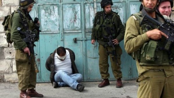 جنود اسرائيليون يحيطيون بفلسطيني معتقل ومعصوب العينين خلال عملية في الضفة الغربية 
