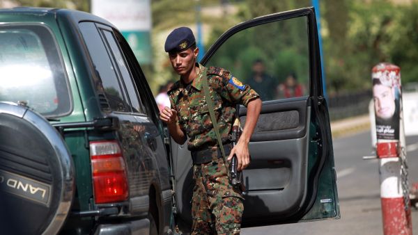 A police trooper inspects a vehicle at the entrance of the Sanaa International Airport (AFP/MOHAMMED HUWAIS)