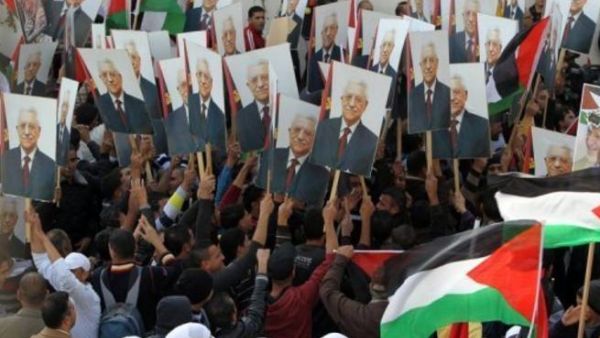 فلسطينيون يرفعون صورا للرئيس الفلسطيني محمود عباس في رام الله

