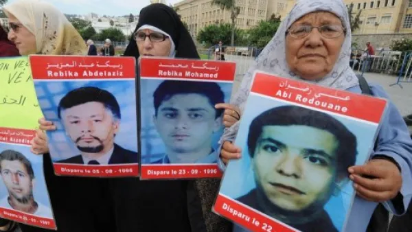 نساء يحملن صور اقاربهن المفقودين في الجزائر