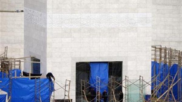 عمال فلسطينيون يزيلون ستائر بلاستيكية وضعت امام ضريح عرفات بعد اخذ عينات من رفاته لتحليلها لتحديد سبب الوفاة
