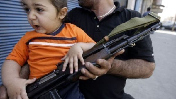 مسلح يحمل طفلا في طرابلس مسلح يحمل طفلا في طرابلس